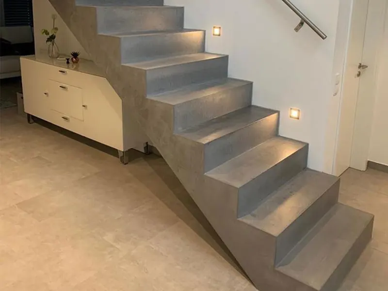 Freitragende Treppe mit Stufen aus grauem Mikrozement